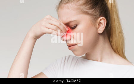 Sad woman holding nose because sinus pain Stock Photo
