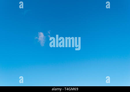 Singular fluffy cloud in a seamless gradient blue sky Stock Photo