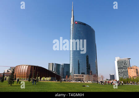 Milan, Italy - March 31, 2019. People enjoy in Porta Nuova District Park, the UniCredit skyscraper, reflections in a spring day (designed by Cesar Pel Stock Photo