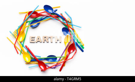 Colored single-use plastic forks and spoons in round shape on white background, top view, copy space. Save the earth concept Stock Photo