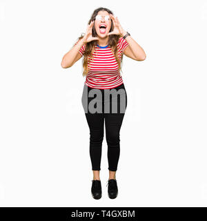 Young beautiful woman wearing glasses Shouting angry out loud with hands over mouth Stock Photo