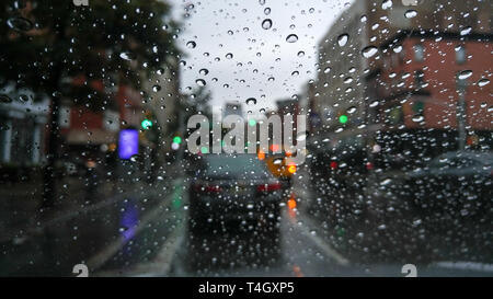Looking at traffic through a windshield covered with raindrops on a dreary and gloomy day Stock Photo