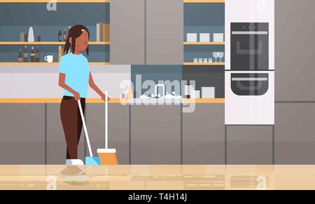 housewife sweeping floor with broom and scoop african american girl doing housework house cleaning concept modern kitchen interior female character Stock Vector