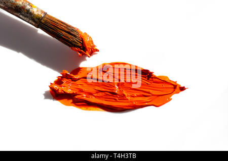 Orange oil paint and brush on white background Stock Photo