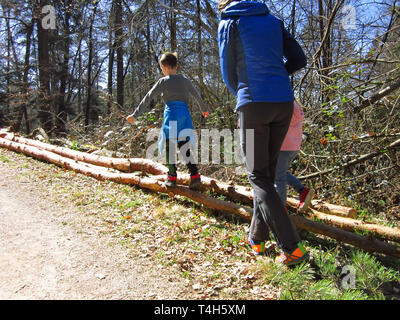 Kids walking on tree trunks stimulates motor development and balance Stock Photo