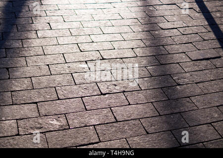 sun shadows on the tile paved sidewalk with perspective. background, lighting. Stock Photo