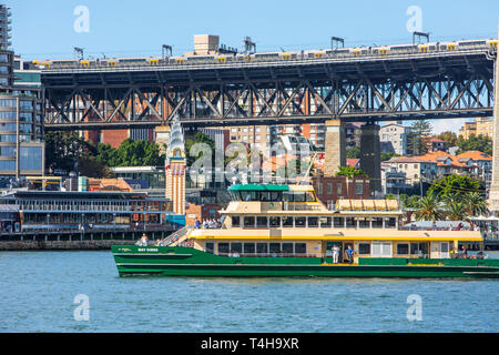 Sydney ferry named MV May Gibbs on Sydney harbour passing the sydney harbour bridge,Sydney,Australia Stock Photo