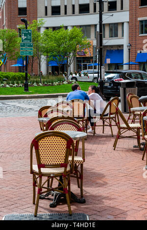 Baltimore, MD, USA --April 13, 2019-- A couple sitting at an outdoor table is engaged in a conversation Stock Photo