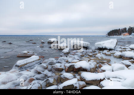 Boulders covered with snow along the Baltic sea shore, Estonia. Winter frost. Stock Photo
