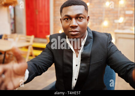 Strong powerful african american man in black suit taking selfie and holding camera with hands. Stock Photo
