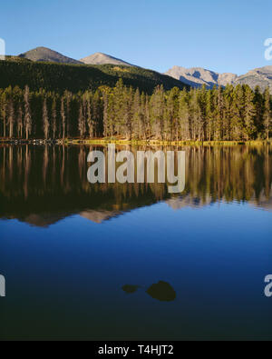 USA, Colorado, Rocky Mountain National Park, Peaks of the continental divide reflect in Sprague Lake at sunrise. Stock Photo