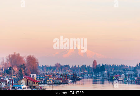 Evening view of the Columbia River with floating houses and boats and yachts moored at berths on the background of the snow covered mountain Mount Hoo Stock Photo