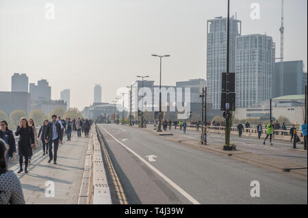 London, UK. 17th April, 2017. Extinction Rebellion Climate Change protesters continue a blockade of Waterloo Bridge to vehicle traffic but with a heavier police presence. Morning commuters cross the bridge walking to work in the City. Credit: Malcolm Park/Alamy Live News. Stock Photo
