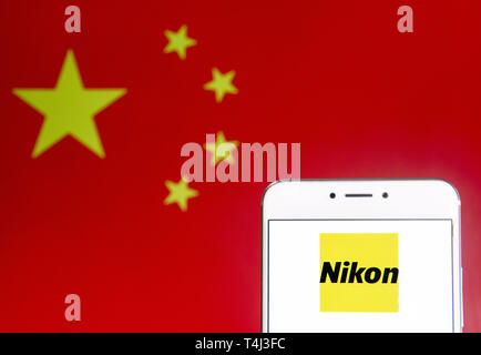 April 6, 2019 - Hong Kong - In this photo illustration a Japanese multinational electronics corporation and manufacturer Nikon logo is seen on an Android mobile device with People's Republic of China flag in the background. (Credit Image: © Budrul Chukrut/SOPA Images via ZUMA Wire) Stock Photo