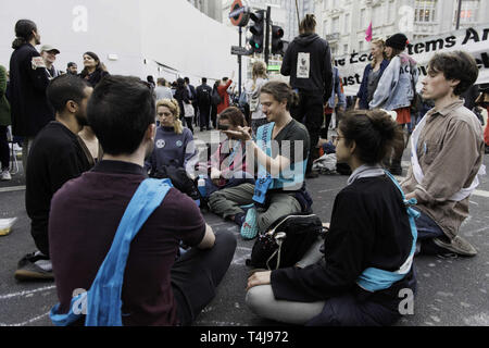 London, Greater London, UK. 17th Apr, 2019. Activists seen having a meditation session during the Extinction Rebellion Strike in London. Environmental activists from Extinction Rebellion movement hold for third consecutive day Oxford Circus in London. Activists has been parked a pink boat in the middle of Oxford Circus junction blocking the streets and causing disruptions, Police have been arresting protesters that refuse to head to Marble Arch. Extinction Rebellion demands from the government direct actions on the climate, reduce carbon emissions to zero by 2025. (Credit Image Stock Photo