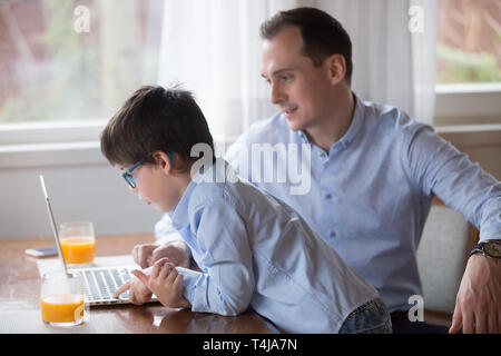 Father and son playing computer game on weekend at home Stock Photo