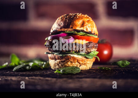 Tasty beef burger with spinach leaves salad onion tomato and cheese Stock Photo