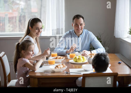Happy family with children eating morning breakfast at kitchen Stock Photo