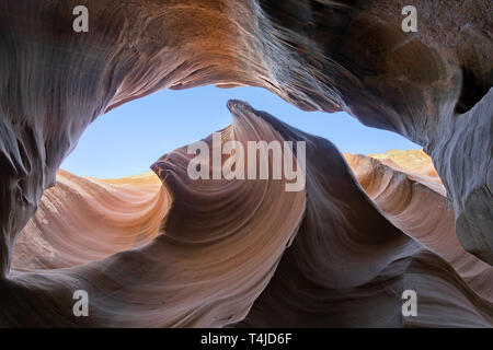 These slot canyons are formed by erosion producing a flowing shape to the sandstone walls. Sunlight producing a beautiful ethereal lighting effect. Stock Photo
