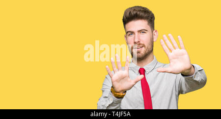 Young handsome business man Smiling doing frame using hands palms and fingers, camera perspective Stock Photo