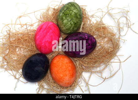 Colourfully painted Easter eggs with straw Stock Photo