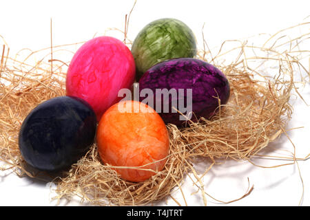 Colourfully painted Easter eggs with straw Stock Photo