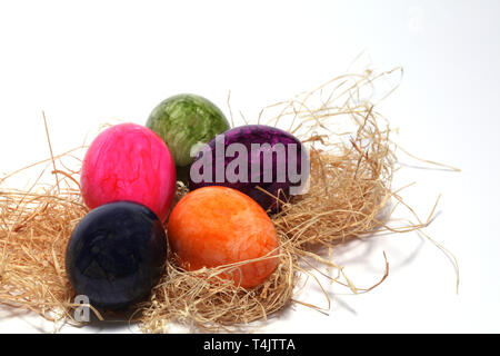 Colourfully painted Easter eggs with straw Stock Photo