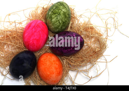 Colourfully painted Easter eggs with straw Stock Photo