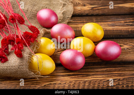 Easter eggs on a sackcloth background. Happy easter Bright multicolored shiny easter eggs. Background with easter eggs. wooden background Stock Photo
