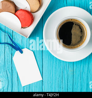 Multicolored macaroons, empty postcard, coffee Stock Photo