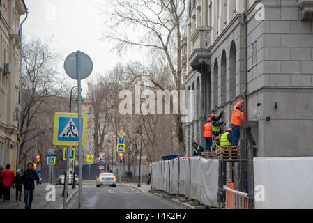 April 2019, Moscow, Russia. Workers in bright vests repair the wall of the building Stock Photo