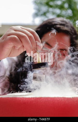 Female Student Demonstrates Quantum Magnetic Levitation and Suspension Effect. A splash of liquid nitrogen cools a ceramic superconductor forcing it t Stock Photo