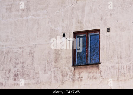 An old window on a building exterior in Tallinn, Estonia. Both the window and the wall have seen better days. Stock Photo