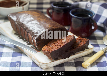 Vegan Mexican chocolate cake with chili, cinnamon and chocolate icing served with coffee. Selective focus. Stock Photo