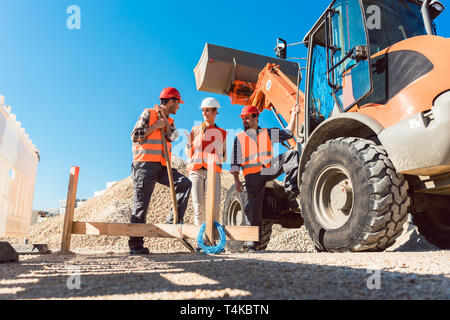 Three workers on roadworks construction site Stock Photo