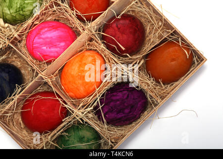 Colourfully painted Easter eggs in a wooden box with straw Stock Photo