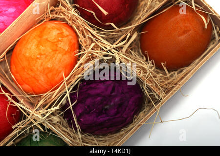Colourfully painted Easter eggs in a wooden box with straw Stock Photo