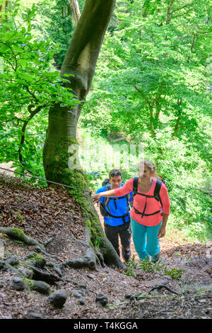 Couple hiking on natural trail in forest Stock Photo