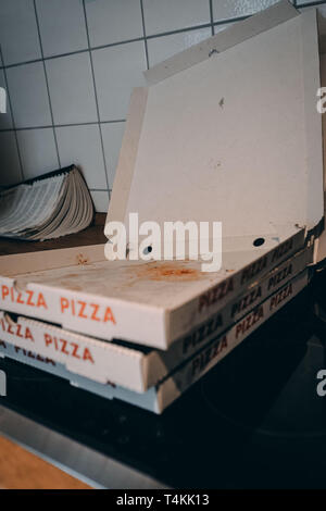 Empty pizza boxes in a kitchen the day after a party. Stock Photo