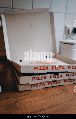 Empty pizza boxes in a kitchen the day after a party. Stock Photo