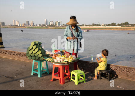 Local woman selling fruit on the riverside at sunset near the Royal Palace, Sisowath Quay, Phnom Penh, Cambodia, Southeast Asia, Asia Stock Photo