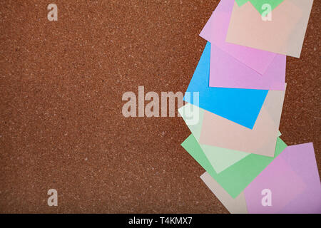 Corkboard with notes. Colored paper on corkboard. Stock Photo