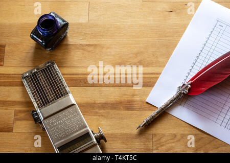vintage adding machine on ledger purchases journal page with feather quill and ink pot Stock Photo