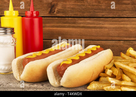 Duo of hot dogs and french fries on table. Fast food restaurant concept. Close up. Copy space for your text. Stock Photo