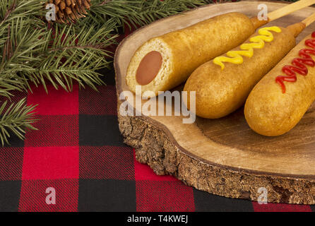 Group of corn dogs on a wooden plank. Fast food restaurant concept. Close up. Stock Photo