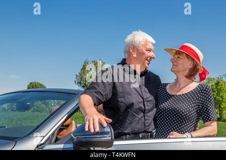 Senior couple in convertible car enjoying day trip Stock Photo