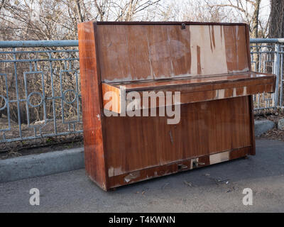 side view on abandoned retro classical wooden piano at city park. concept of open air concert Stock Photo