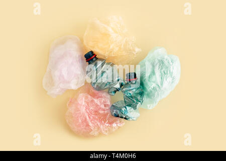 Plastic bags and bottles on yellow background. No plastic garbage concept. Stock Photo