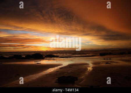 Sunset after heavy rain with arcus shelf storm clouds and stones in the ocean on tropical island Ko Lanta, Thailand Stock Photo