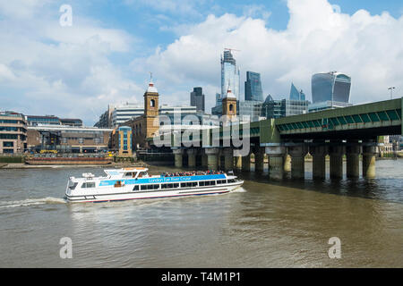 A tourist boat from the London Eye River Cruise passing under Cannon Street Bridge on the River Thames in London. Stock Photo